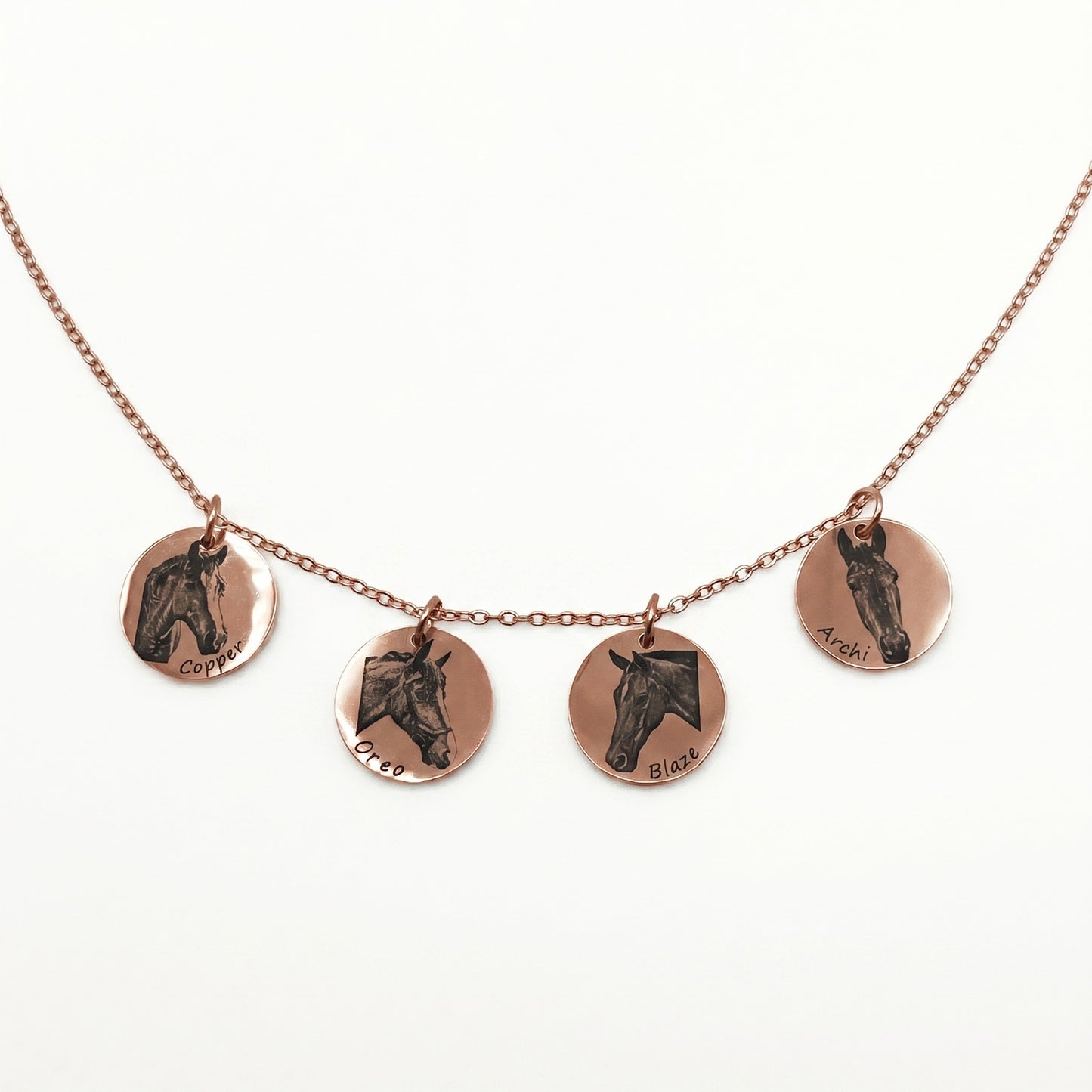 Necklace with four Rose gold pendants featuring horse portraits on a white background