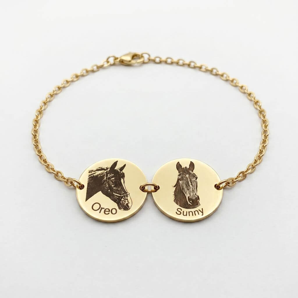 Gold bracelet with horse head charms and engraved names on a white background