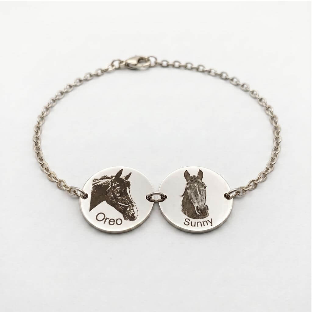 Silver bracelet with two engraved horse head images on a white background