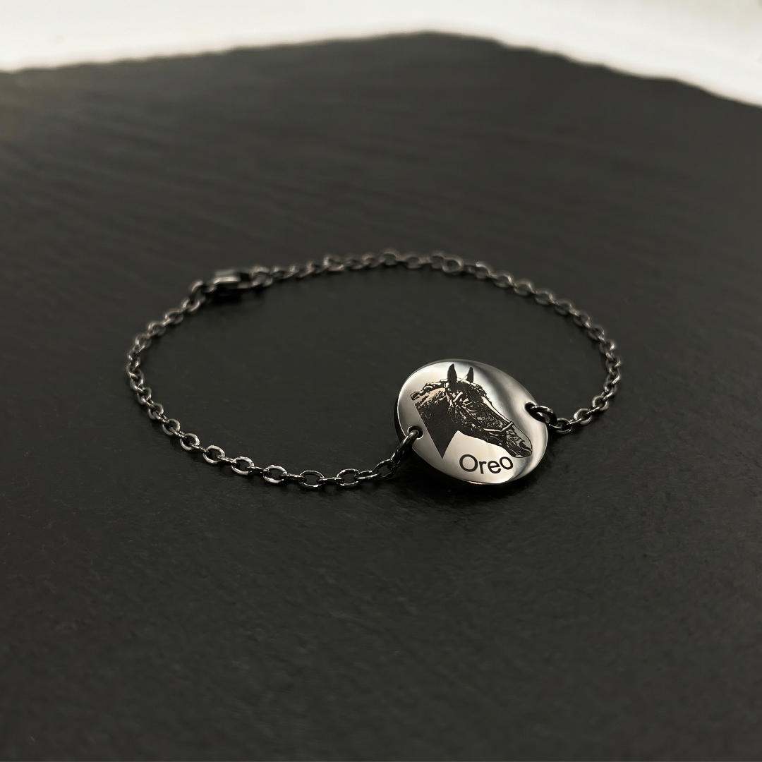 Silver bracelet with a round pendant on a dark surface, BR-P1-ST