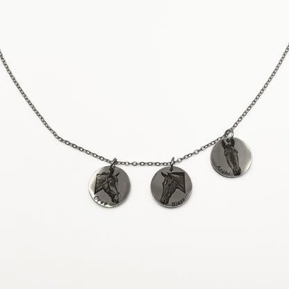 Necklace with three silver circular pendants featuring engraved horse faces on a white background