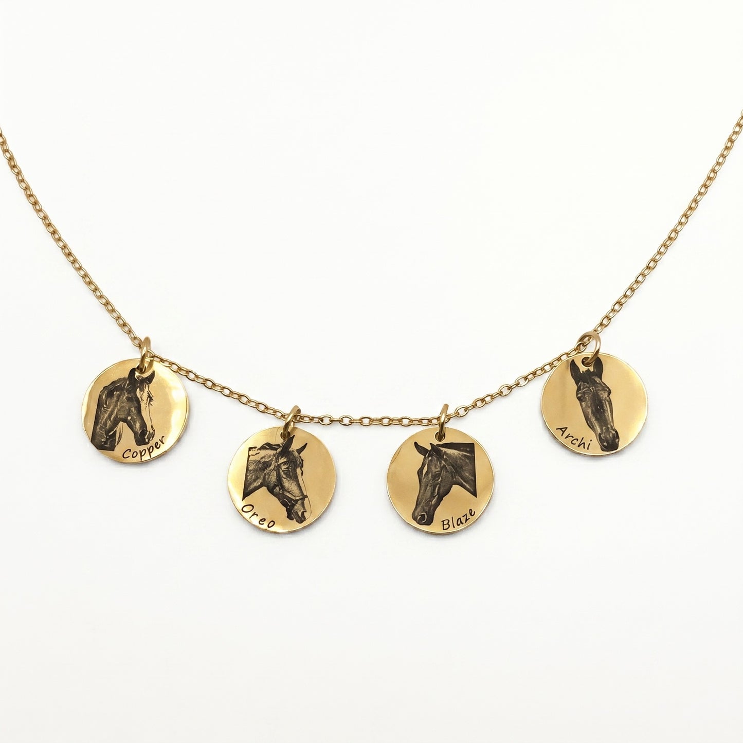 Gold necklace with four round pendants featuring horse illustrations on a white background