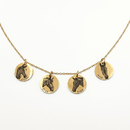 Gold necklace with four round pendants featuring horse illustrations on a white background